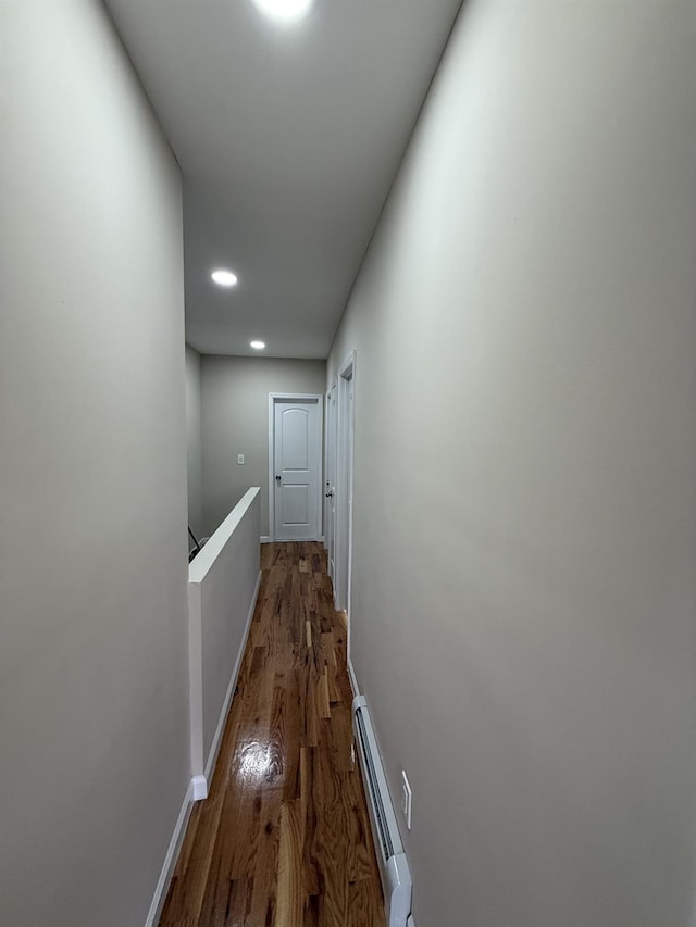 hall with hardwood / wood-style floors and a baseboard radiator