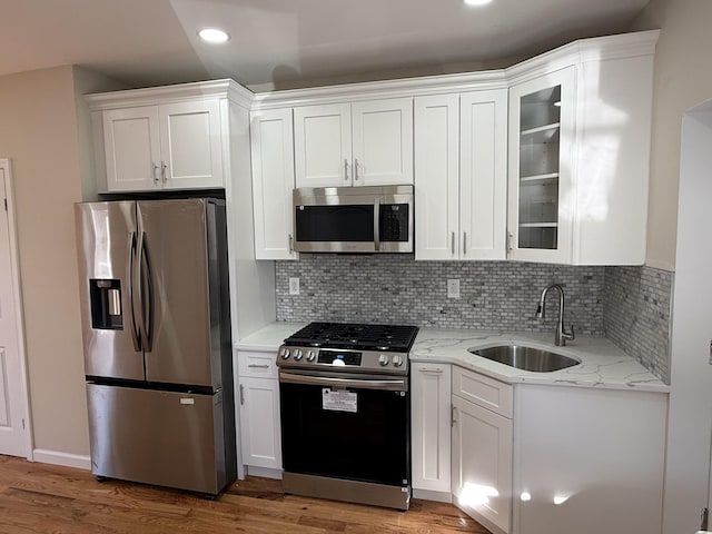 kitchen featuring white cabinets, sink, light wood-type flooring, and stainless steel appliances