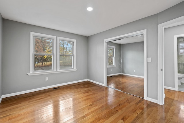 unfurnished bedroom featuring hardwood / wood-style floors and a closet