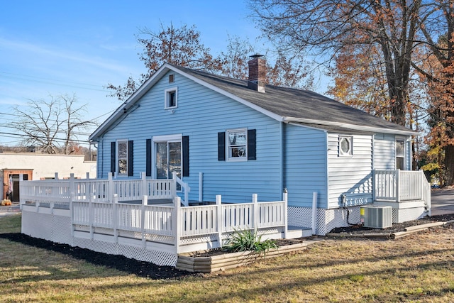 rear view of house with a lawn, central AC unit, and a deck