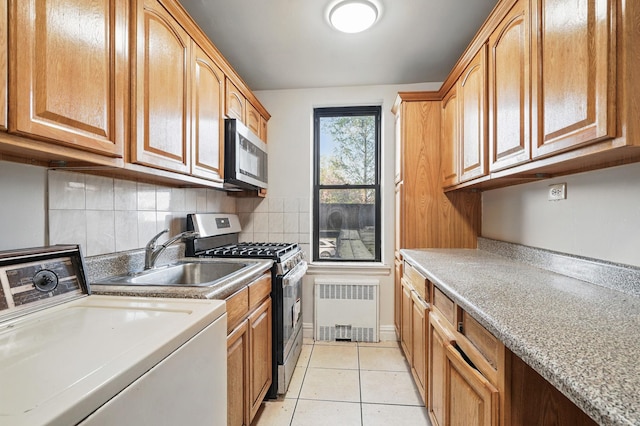 3555 Kings College Pl Unit 1H, Bronx, NY 10467 - kitchen with radiator heating unit, a sink, decorative backsplash, light countertops, and appliances with stainless steel finishes