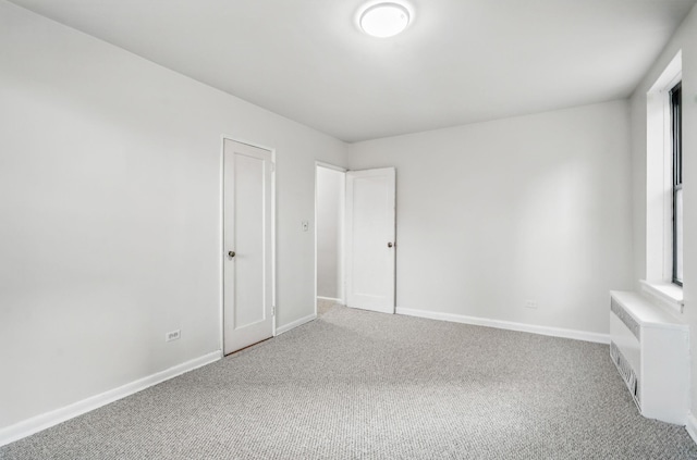3555 Kings College Pl Unit 1H, Bronx, NY 10467 - empty room featuring light colored carpet, radiator, and baseboards