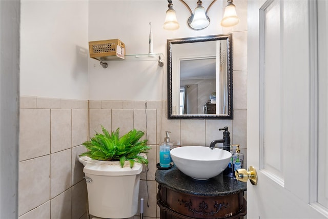 bathroom featuring vanity, toilet, and tile walls