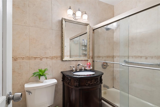 full bathroom with vanity, toilet, enclosed tub / shower combo, and tile walls