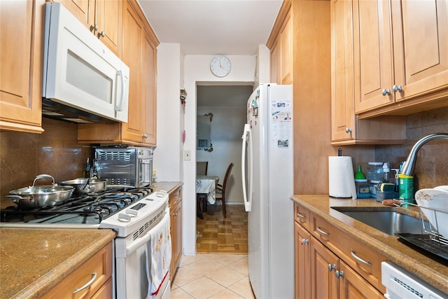 kitchen with decorative backsplash, white appliances, sink, and light tile patterned floors