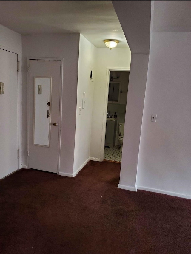 unfurnished room with dark carpet