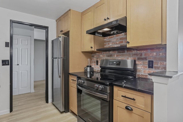 500 High Point Dr Unit 709, Hartsdale, NY 10530 - kitchen with appliances with stainless steel finishes, under cabinet range hood, light brown cabinets, dark countertops, and light wood-style flooring