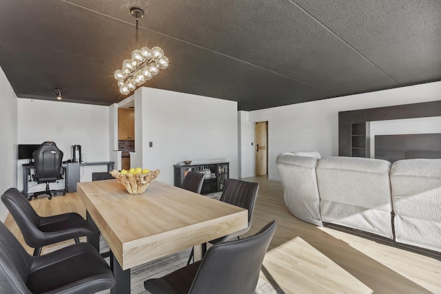 500 High Point Dr Unit 709, Hartsdale, NY 10530 - dining area featuring light wood-style flooring, a chandelier, and a textured ceiling
