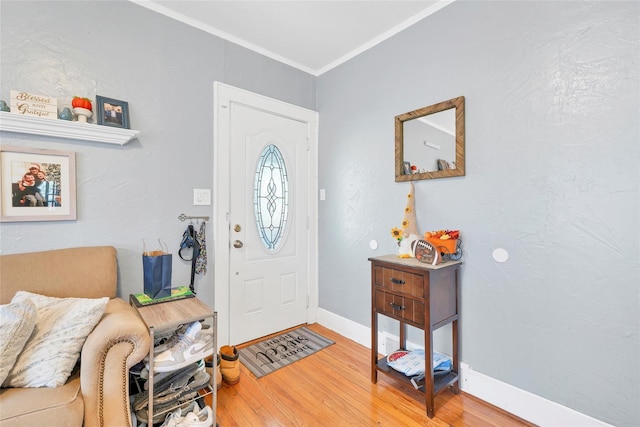 foyer with hardwood / wood-style flooring and crown molding