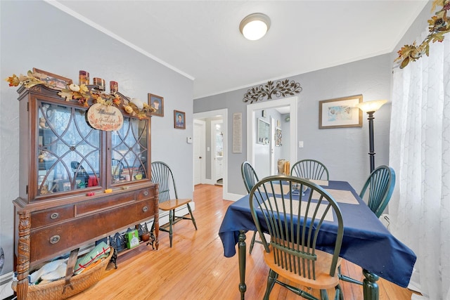 dining space featuring hardwood / wood-style flooring and crown molding