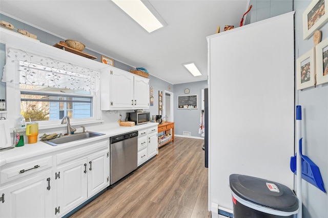 kitchen with white cabinets, wood-type flooring, sink, and appliances with stainless steel finishes