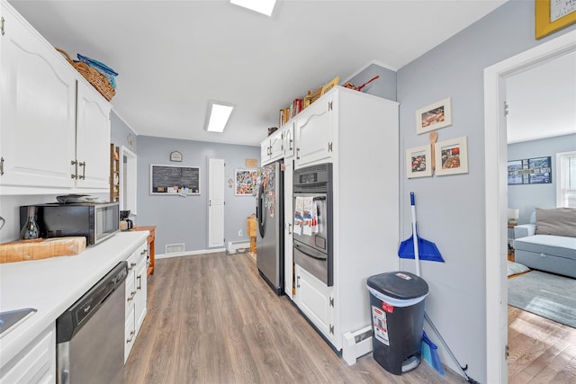 kitchen with sink, white cabinets, stainless steel appliances, and light wood-type flooring