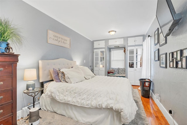 bedroom featuring a baseboard radiator and light wood-type flooring