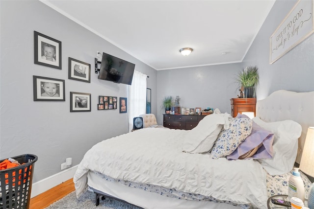 bedroom with wood-type flooring and ornamental molding