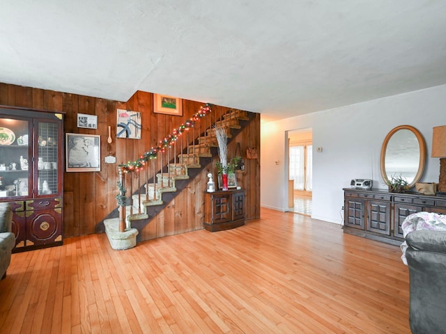 unfurnished living room with hardwood / wood-style flooring and wooden walls