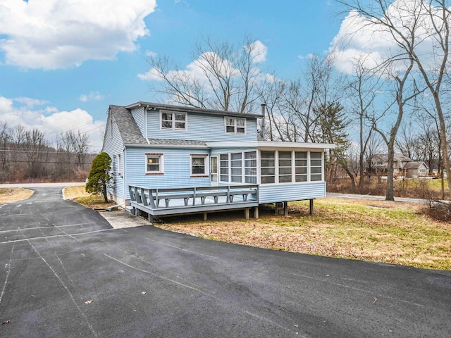 exterior space featuring a wooden deck and a sunroom