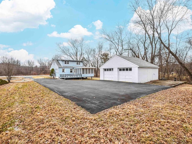 exterior space featuring a garage, an outbuilding, and a deck