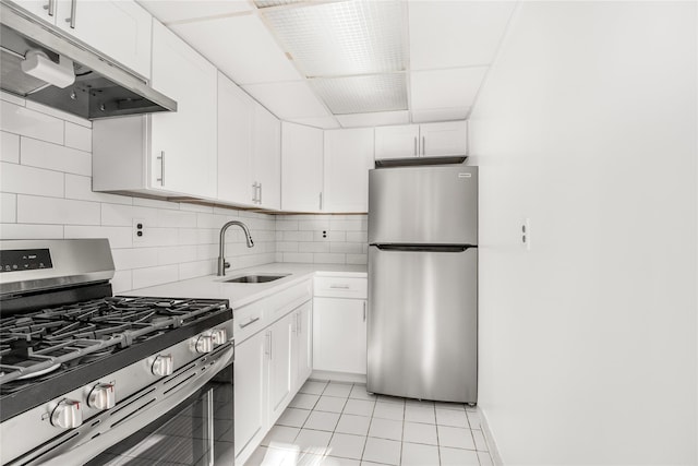 kitchen featuring backsplash, white cabinets, sink, appliances with stainless steel finishes, and light tile patterned flooring