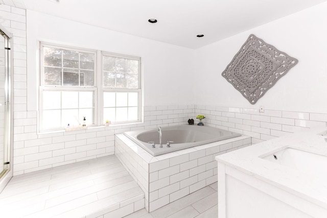full bath with plenty of natural light, a shower with shower door, and a bath
