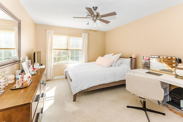 bedroom featuring baseboards, light colored carpet, and ceiling fan