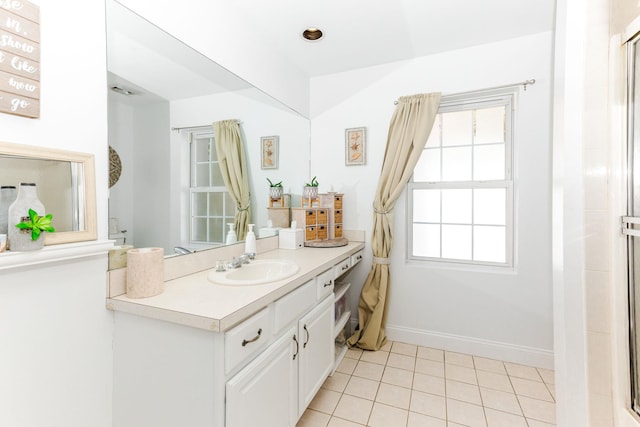bathroom with vanity, baseboards, a shower with shower door, and tile patterned floors