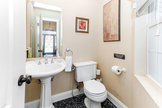 bathroom featuring toilet, baseboards, and marble finish floor