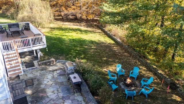 view of yard with a view of trees, an outdoor fire pit, a deck, and a patio area