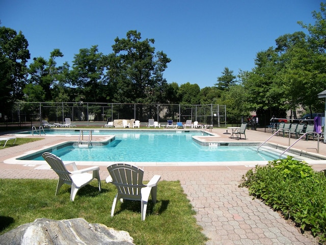 community pool featuring fence and a patio area