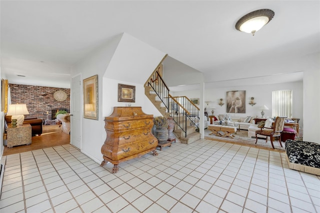 interior space featuring brick wall, a fireplace, and light tile patterned floors