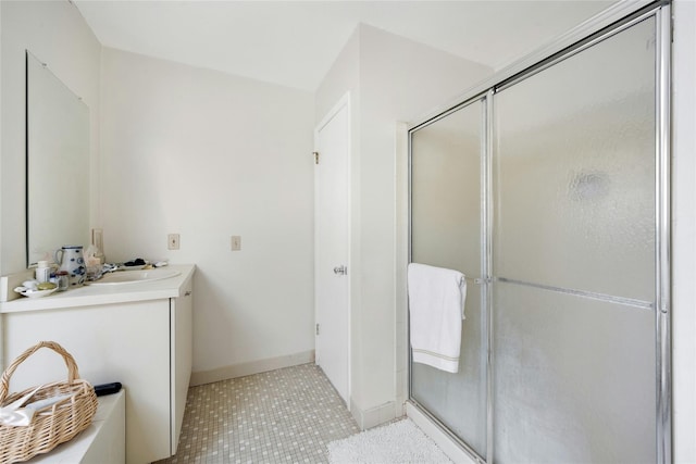 bathroom with a shower with door, vanity, and tile patterned floors