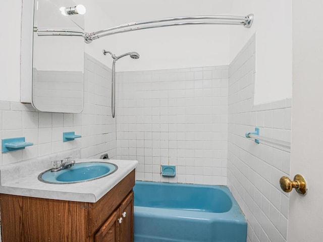 bathroom with vanity, decorative backsplash, and tiled shower / bath combo