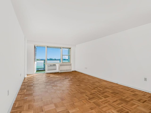 unfurnished room with radiator and light parquet flooring