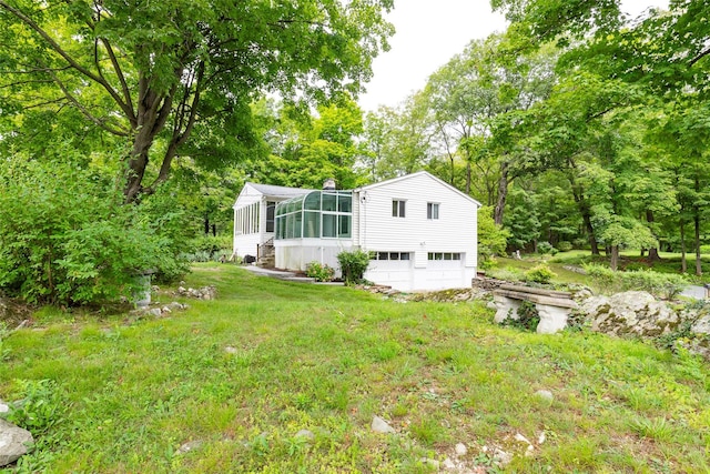 back of house featuring a sunroom and a yard