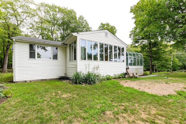 rear view of property with a sunroom and a yard