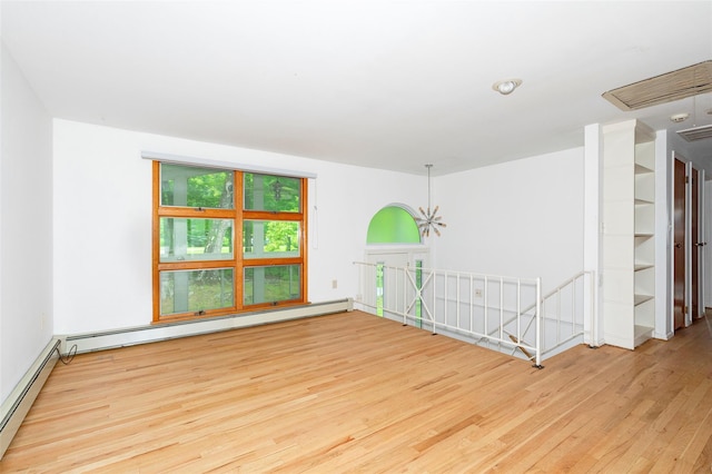 unfurnished room with hardwood / wood-style floors and baseboard heating