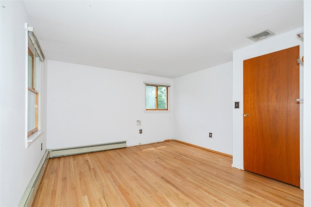 spare room featuring light hardwood / wood-style floors and a baseboard heating unit