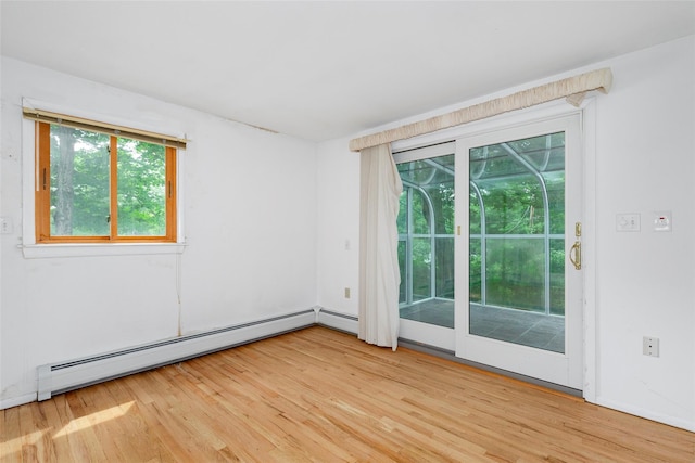 spare room featuring light wood-type flooring and a baseboard radiator