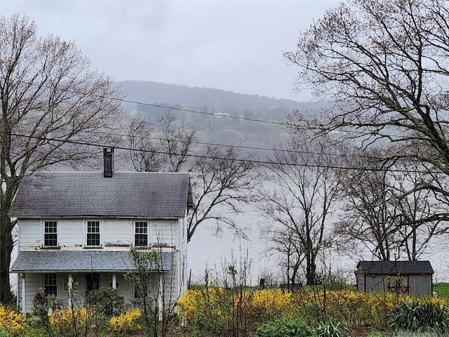 view of home's exterior with a mountain view and a shed