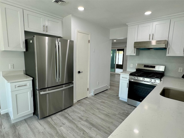 kitchen featuring white cabinets, appliances with stainless steel finishes, light wood-type flooring, and baseboard heating