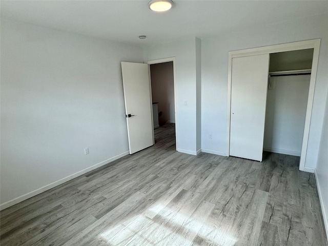 unfurnished bedroom featuring a closet and light wood-type flooring