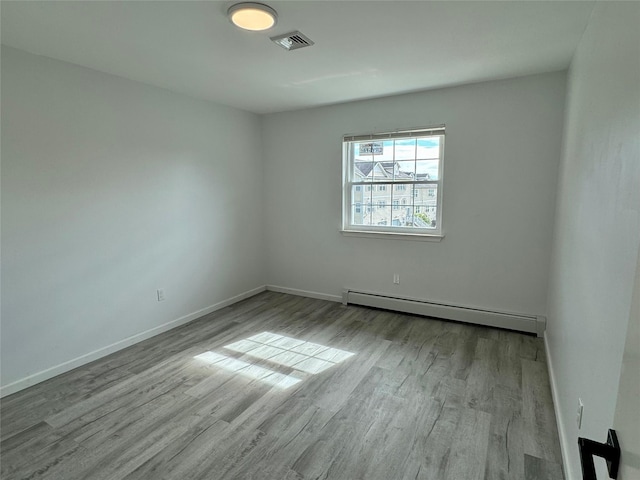 empty room featuring light hardwood / wood-style flooring and a baseboard radiator