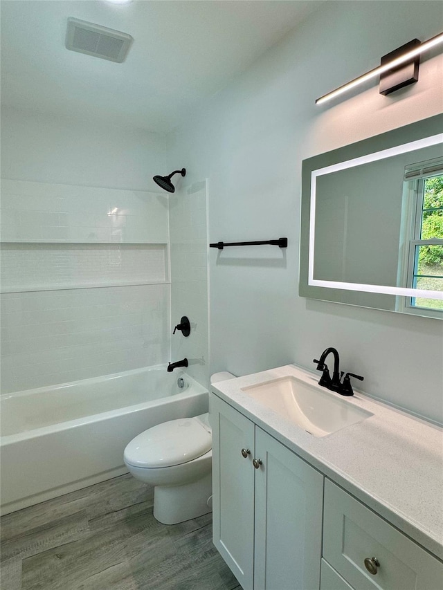 full bathroom featuring shower / tub combination, hardwood / wood-style floors, vanity, and toilet