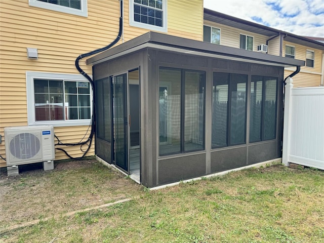 back of house featuring a yard, a sunroom, and ac unit