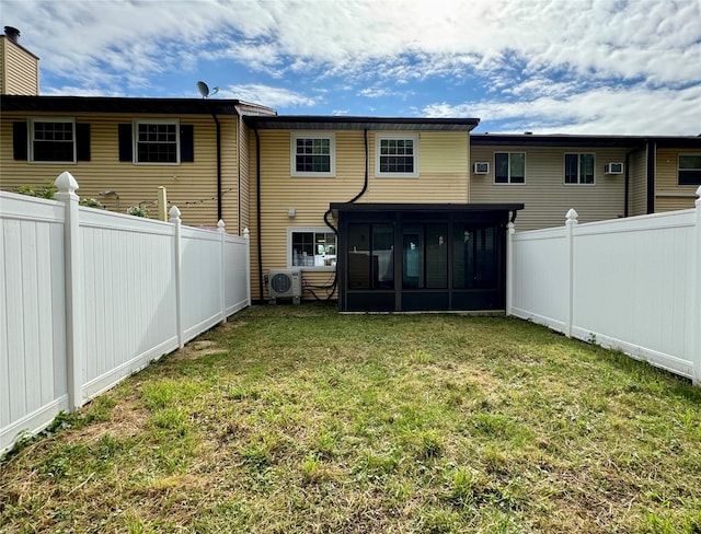 rear view of property featuring a lawn, a sunroom, and ac unit