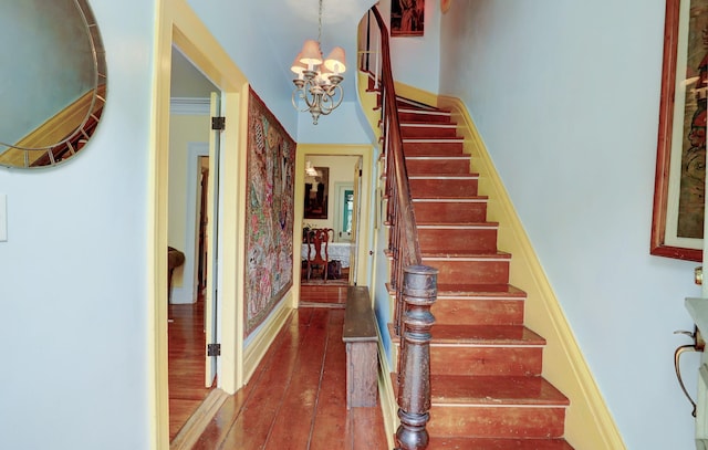 stairs with wood-type flooring and a notable chandelier