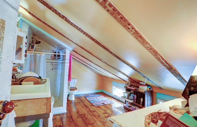 additional living space featuring hardwood / wood-style floors and vaulted ceiling