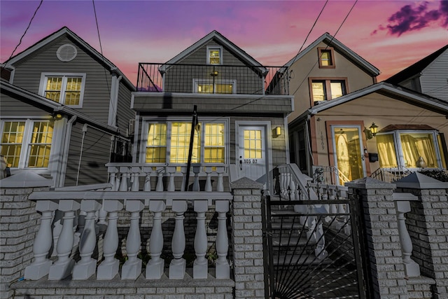 back house at dusk featuring a balcony