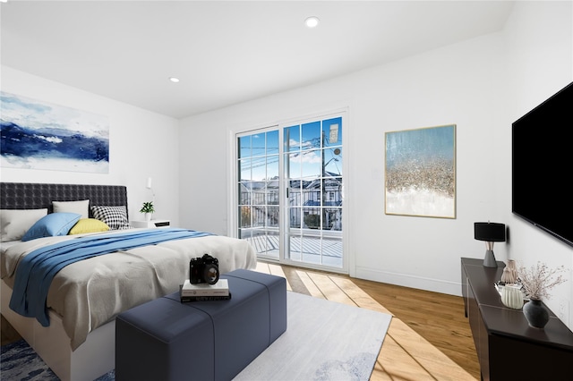 bedroom featuring light hardwood / wood-style floors, access to exterior, and multiple windows