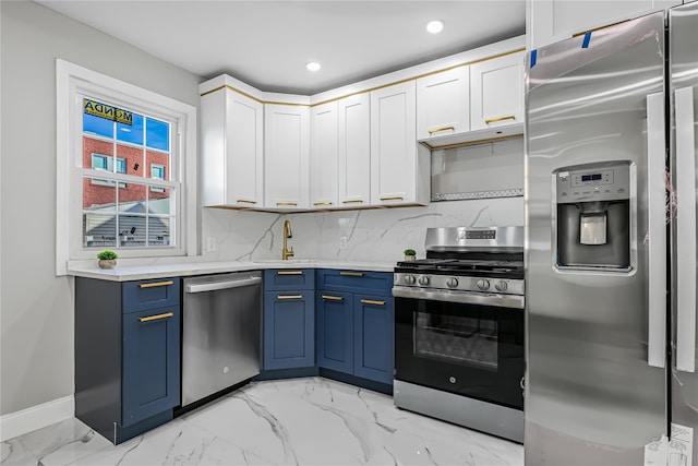 kitchen featuring white cabinets, sink, decorative backsplash, blue cabinetry, and appliances with stainless steel finishes