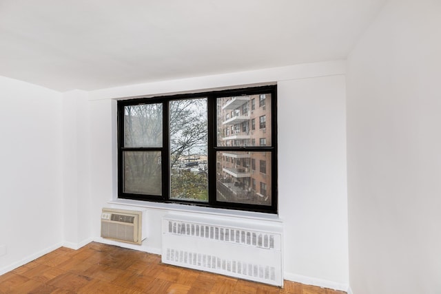 details with an AC wall unit, radiator heating unit, and wood-type flooring